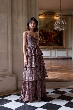 a woman in a dress standing on a checkered floor