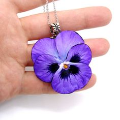 Pansies necklace from polymer clay . Get into the spirit of springtime any time of year with this charming Pansy necklace. A symbol of free-spiritedness and tender affection, this Pansy pendant captures the beauty of real pansies in an easy-to-wear piece of art. Each petal retains its vibrant purple hues, creating a pansy eye jewelry piece that is more than just a fashion statement - it's a statement of the soul. Dare to express yourself with jewelry that speaks to nature's unique craftsmanship. Whimsical Purple Necklace For Gifts, Whimsical Purple Necklace For Gift, Purple Flower-shaped Whimsical Jewelry, Hand Painted Flower Necklace For Gift, Whimsical Purple Flower Jewelry, Whimsical Purple Flower-shaped Jewelry, Handmade Polymer Clay Jewelry With Flower Pendant, Hand Painted Flower Polymer Clay Jewelry, Handmade Polymer Clay Flower Pendant Jewelry