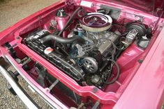 an engine in the trunk of a pink car