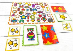 colorful paper cut outs and stickers on a white wooden table with scissors, pencils and markers