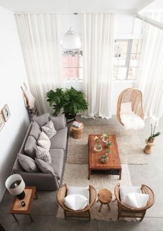 an aerial view of a living room with furniture and plants in the corner, including a coffee table