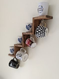 coffee cups are lined up on wooden shelves