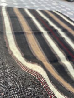 a close up of a black and white rug with red stitching on it's edges