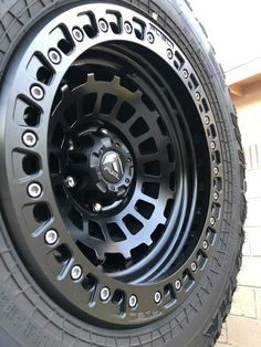 the wheel and tire of a truck parked in front of a building