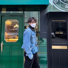 a person wearing a face mask standing in front of a store