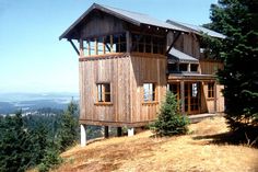 a wooden house sitting on top of a hill