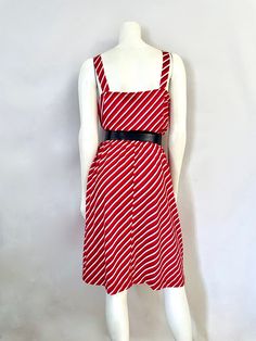 "Vintage Women's 80's Tabby, Pink, Striped, Sleeveless, Skater Dress (L) 5561 This Ladies Dress comes in a dark pink cotton/polyester blend with a striped print in white and purple with shoulder straps, a single button detail, with a loose waist, and full flowing skirt that sits at the knee. The top fabric does have stretch, the bottom skirt is all cotton and does not stretch. **Belt not included.* Cotton/Polyester Blend *Belt not included. *The waistband once was a stretchy elstic waistband but Vintage Striped Sleeveless Dress, 1970s Sleeveless Cotton Dress, 1970s Style Sleeveless Cotton Dress, 1970s Red Summer Dresses, 1970s Style Red Summer Dresses, Red 1970s Style Summer Dress, Geometric Top, Stretch Belt, Flowing Skirt