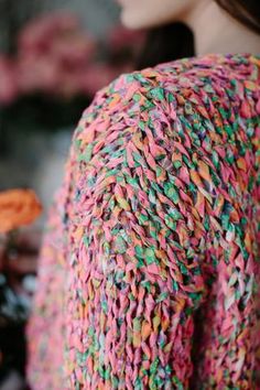 a woman wearing a colorful sweater with sprinkles on it