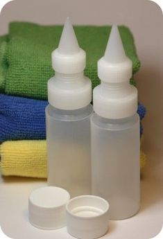 two bottles and one container are sitting next to towels