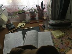 an open book sitting on top of a desk next to a computer keyboard and mouse