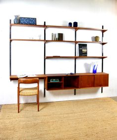 a room with a table, chair and shelves on the wall next to each other