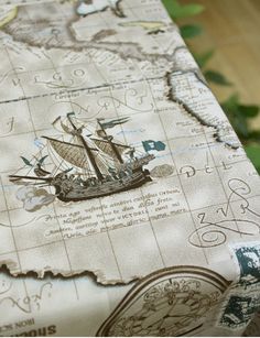 a table cloth with a pirate ship on the front and map in the back, along with green leaves