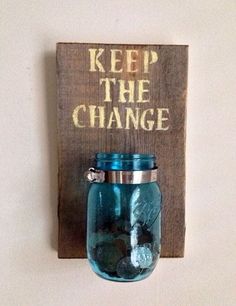 a mason jar hanging on a wall with the words keep the change painted on it