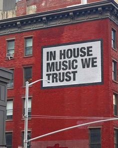 a red brick building with a large sign on it's side that says in house music we trust