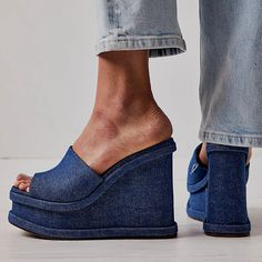 Step back in time with these Blue Denim Platform Mules. Vintage charm meets modern style in these open-toe wedge sandals, perfect for a touch of nostalgia with a contemporary twist. Color: Blue Material: Denim Heel Type: Wedge heel Heel height: 4.72" / 120 mm approx Product measurements were taken using size 8. Please note that measurements may vary by size. Toe: Open toe With platform Handcrafted US sizing. Fits true to size. Denim Platform Wedge Sandals With Open Toe, Blue Slip-on Mules With Wooden Heel, Denim Mules, High Heel Thong Sandals, Blue Wedge Heel Sandals With 4-inch Heel, Slip-on Platform Wedge Sandals With Open Toe, Denim Heels, Blue Wedges, Cowboy Shoes