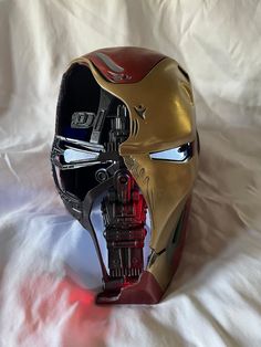 an iron man mask is shown on a white sheet with red light coming from it