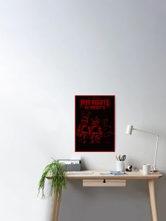 a desk with a plant on it next to a poster that says five nights in red