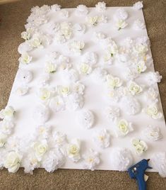 the flowers are laid out on the floor to be made into a wall decoration with scissors