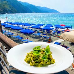 a white plate topped with food on top of a beach