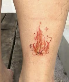 a woman's leg with a tattoo on it that has a fire and stars