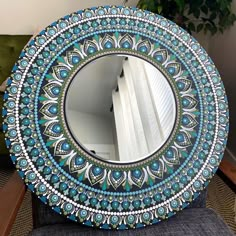 a blue and white mirror sitting on top of a chair