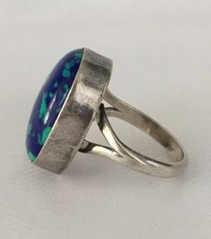 This play of light and dark blue on this stone is just beautiful. The ring is 6 1/4 and the stone is 3/4" by 1/2". It is bezel set an the silver band is smooth and comfortable to wear. Wear it with your other silvers or wear it alone. It is an eye catching ring. It is marked Sterling and has the initial L. It is in wonderful vintage condition. Please see all photos and feel free to ask any questions.Thank you for looking! Blue Cabochon Opal Ring, Blue Oval Opal Ring With Polished Finish, Modern Blue Rings With Large Stone, Blue Turquoise Ring With Inlay, Blue Rings With Large Stone For Healing, Blue Oval Rings With Inlay, Blue Cabochon Opal Ring In Sterling Silver, Modern Blue Cabochon Ring, Modern Blue Turquoise Gemstone Ring