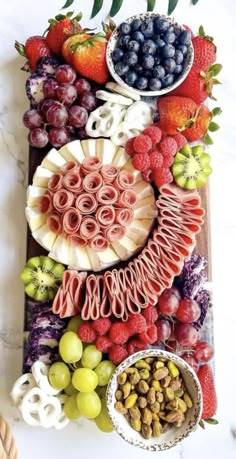 an assortment of fruits and vegetables laid out on a cutting board