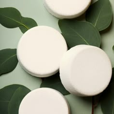 three marshmallows sitting on top of green leaves next to eachother