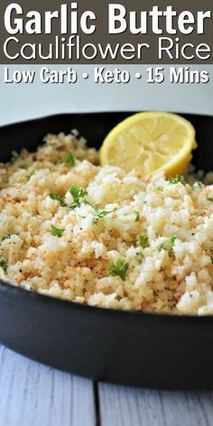 garlic butter cauliflower rice in a skillet with lemon wedges