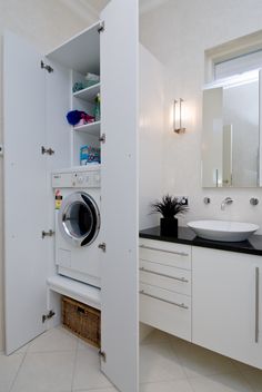 a washer sitting inside of a bathroom next to a sink