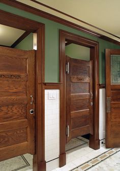 three wooden doors in a room with tile flooring and rugs on the floor