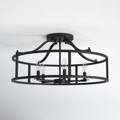 a black chandelier hanging from the ceiling with four lights on each one side