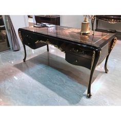 an antique desk with marble top and gold trimmings