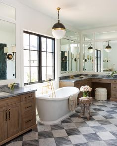 a bathroom with a checkered floor and large bathtub in the middle of it