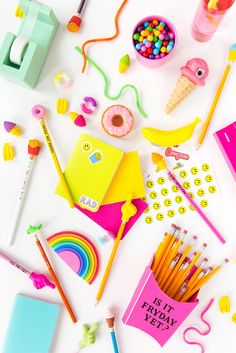 there are many school supplies on this white surface together, including pens and pencils