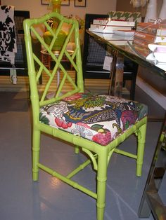 a green chair sitting on top of a gray floor next to a table with books