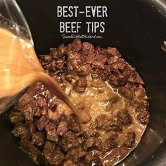 the beef is being stirred with gravy in the slow cooker to be cooked