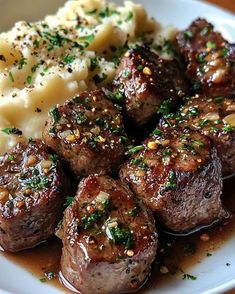 some meatballs and mashed potatoes on a white plate