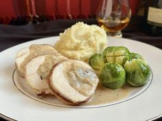 a white plate topped with meat, potatoes and brussel sprouts