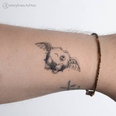 a tattoo on the arm of a person with a cross and an owl drawn on it