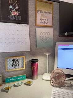 a laptop computer sitting on top of a desk next to a cup and other items