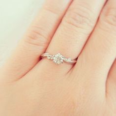 a woman's hand with a diamond ring on it