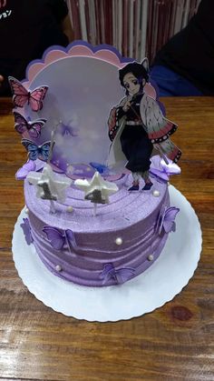 there is a purple cake on the table with butterflies around it and a girl holding a butterfly