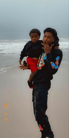 a man holding a child on the beach