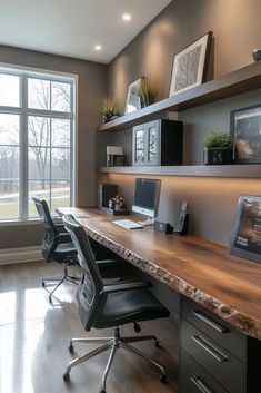 a desk with two computers on it in front of a large window and some shelves