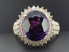 Extremely impressive 6 carat Amethyst and Diamond dress/cocktail ring. Boosting a stunning vibrant oval faceted 6 carat oval Amethyst of beautiful clarity and gorgeous rich royal purple colour. This a very large round natural gemstone that is just stunning. Beautiful rich deep purple colour, but not super dark. The Amethyst is set among a halo of 57 sparkling Diamonds with a further 30 on the shoulders for that added extra sparkle! There are a total of 87 modern brilliant cut sparkling Diamonds Exquisite Oval Amethyst Ring For Formal Occasions, Dazzling Amethyst Ring For Formal Occasions, Oval Amethyst Diamond Ring For Formal Events, Oval Amethyst Diamond Ring For Formal Occasions, Formal Oval Amethyst Diamond Ring, Oval Amethyst Ring With Center Stone For Formal Occasions, Gold Engagement Dress, Royal Purple Color, Engagement Dress