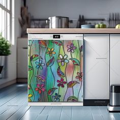 a kitchen scene with focus on the refrigerator and artwork in the cabinet door, as well as an appliance