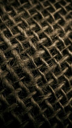 the texture of an old woven cloth is shown in black and brown tones, as well as some other things