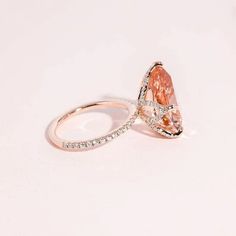 two engagement rings with an orange and white diamond in the middle, on a white background