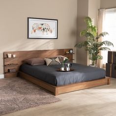 a bed sitting in a bedroom next to a plant on top of a wooden floor